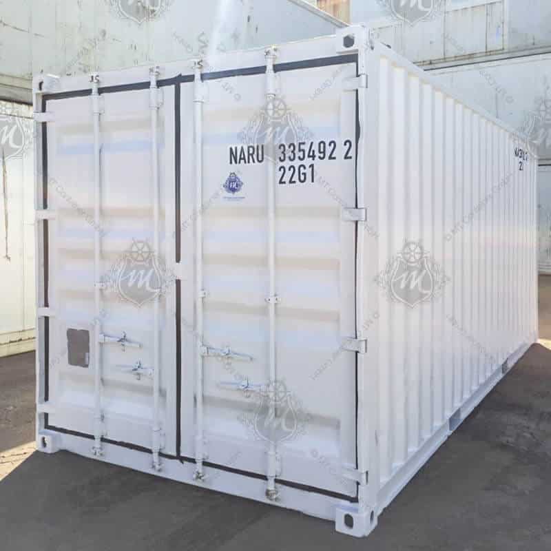 Contenedor de almacenamiento de 20 pies color blanco, fabricado en acero resistente, ideal para almacenamiento industrial y logístico, con puertas dobles de seguridad y ubicado en un patio exterior.