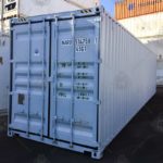Contenedor marítimo High Cube de 40 pies color blanco, fabricado en acero resistente, ideal para transporte internacional y almacenamiento industrial, con mayor altura interior, puertas dobles de seguridad y ubicado en un patio logístico.