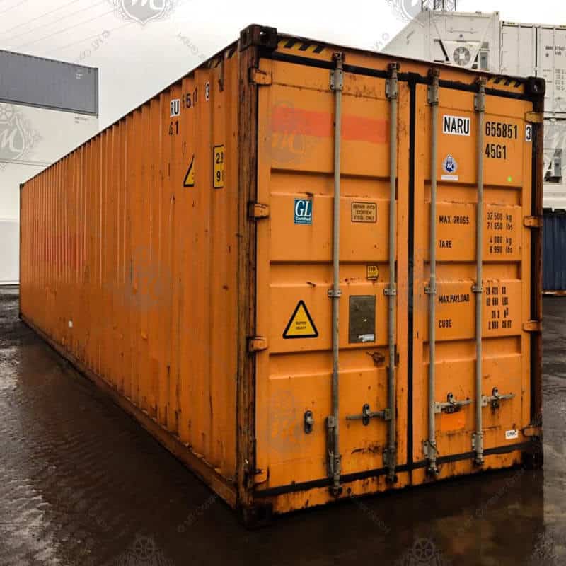 Contenedor de almacenamiento High Cube de 40 pies color naranja, fabricado en acero resistente, ideal para almacenamiento industrial y logístico, con mayor altura interior, puertas dobles de seguridad y ubicado en un patio exterior.